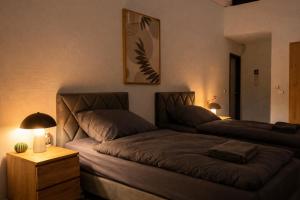 two beds in a room with a couch and a lamp at Monteur- und Ferienunterkunft Ludwigsfelde in Ludwigsfelde