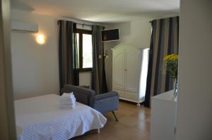 a room with a bed and a chair and a window at B&B casa73 in Cicerale