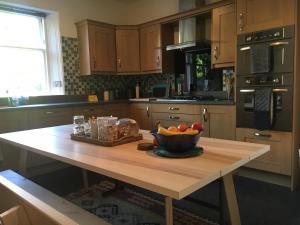 a kitchen with a table with a bowl of fruit on it at Historic Highland Townhouse in Fort William