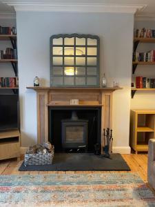 a living room with a fireplace with a mirror above it at Historic Highland Townhouse in Fort William
