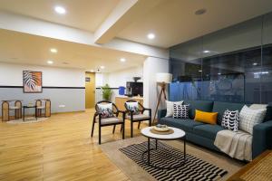 a living room with a blue couch and chairs at Olive Hotel Baner by Embassy Group in Pune