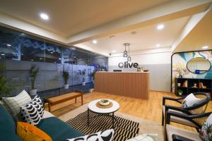 a living room with a couch and a table at Olive Hotel Baner by Embassy Group in Pune