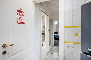 a hallway with a door with a sign that reads keep calm i love koya at Domus Antica Trastevere in Rome
