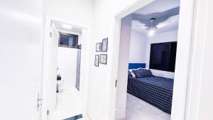 a white room with a bed and a window at Apartamento Centro Ubatuba - Ubatuba House Temporada in Ubatuba