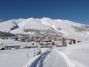 a snow covered mountain with a town in the distance at Apartment Culaischem 1 by Interhome in Zuoz