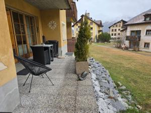 a potted tree sitting on the side of a house at Apartment Culaischem 1 by Interhome in Zuoz +11 photos