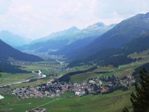 a town in the middle of a valley with mountains at Apartment Culaischem 1 by Interhome in Zuoz
