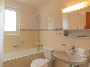 a bathroom with a sink and a toilet and a tub at Apartment Chesa Tscheppa 1 by Interhome in Sils Maria