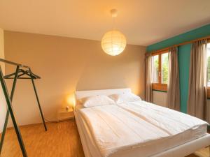 a bedroom with a white bed and a lamp at Apartment Chesa Tscheppa 1 by Interhome in Sils Maria