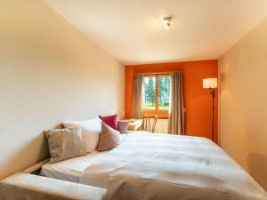 a bedroom with a large bed with pillows at Apartment Chesa Tscheppa 1 by Interhome in Sils Maria +10 photos
