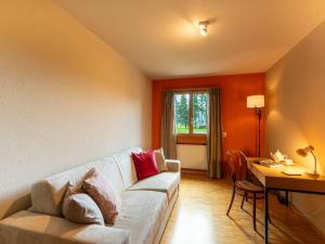 a living room with a white couch and a table at Apartment Chesa Tscheppa 1 by Interhome in Sils Maria