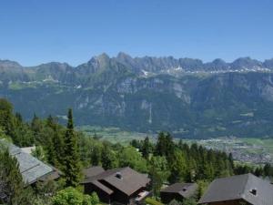 a group of houses on a hill with mountains in the background at Apartment Studio Flumserberg by Interhome in Flumserberg