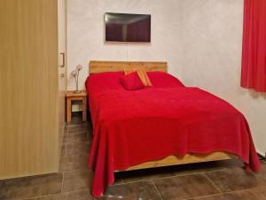 a red bed with a red blanket in a room at Apartment Studio Flumserberg by Interhome in Flumserberg
