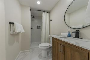 a bathroom with a sink and a toilet and a mirror at 4BR World Cup Fan HQ SuperHost Close to Stadium in Pleasant Valley +19 photos
