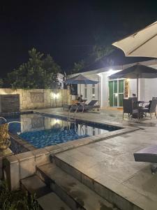 a swimming pool in a backyard at night at Laura villa in Cisarua