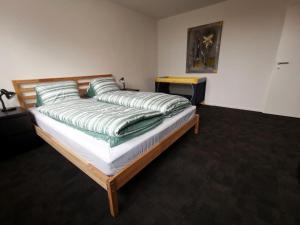 a bed with green pillows on it in a room at Apartment HIRSCHEN by Interhome in Gossau