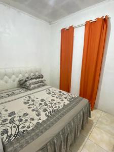a bedroom with a bed and an orange curtain at Laura villa in Cisarua