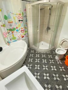 a bathroom with a white toilet and a shower at Laura villa in Cisarua +5 photos