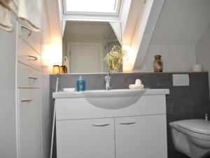 a bathroom with a white sink and a mirror at Apartment Sunnebad Sternenberg by Interhome in Sternenberg +3 photos