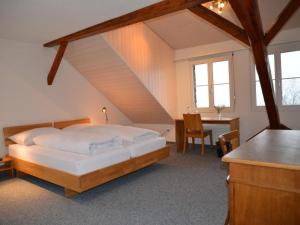 a bedroom with a bed and a desk and a table at Apartment Sunnebad Sternenberg by Interhome in Sternenberg