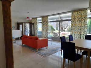 a living room with a red couch and a table at Apartment Pavillon Castagneto by Interhome in Castasegna
