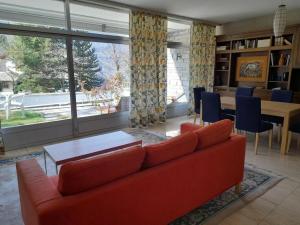 a living room with a red couch and a table at Apartment Pavillon Castagneto by Interhome in Castasegna