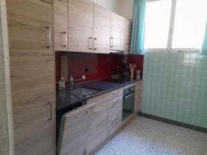 a kitchen with wooden cabinets and a sink at Apartment Pavillon Castagneto by Interhome in Castasegna +13 photos