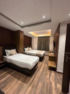 a hotel room with two beds and a television at Royale Serenity in Gangtok