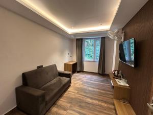 a living room with a couch and a flat screen tv at Royale Serenity in Gangtok