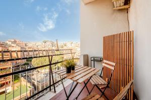 a balcony with a wooden table and a view of a city at Domus Antica Trastevere in Rome
