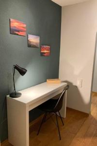 a desk with a lamp and a chair in a room at Apartment Seehof by Interhome in Rorschacherberg