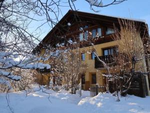 a house covered in snow with trees in front of it at Apartment Wohnung Grün by Interhome in La Punt-Chamues-ch