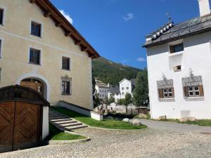 a large white building with a large wooden door at Apartment Wohnung Grün by Interhome in La Punt-Chamues-ch
