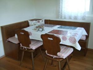 a dining room table with two chairs and a white table at Apartment Ballmoos Ferienwohnung by Interhome in Gais