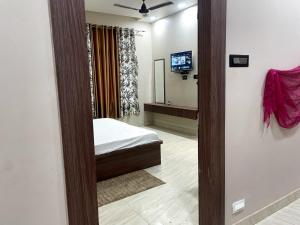 a bedroom with a bed and a television in it at Indian Happy Homes in Siar
