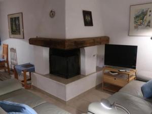 a living room with a fireplace and a television at Apartment Chesa Engel by Interhome in La Punt-Chamues-ch