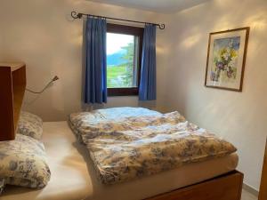 a bedroom with a bed and a window at Apartment Chesa Engel by Interhome in La Punt-Chamues-ch