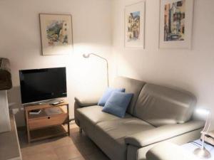 a living room with a couch and a flat screen tv at Apartment Chesa Engel by Interhome in La Punt-Chamues-ch