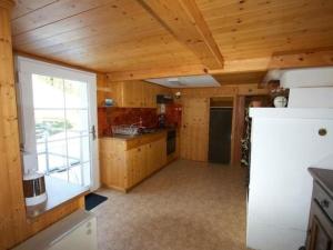 a kitchen with wooden walls and a white refrigerator at Apartment Hasenbüel by Interhome in Ricken