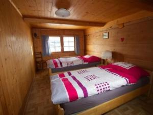 two beds in a log cabin with a window at Apartment Hasenbüel by Interhome in Ricken