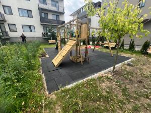 a playground with a slide in a yard with a building at Davids place 2 in Floreşti