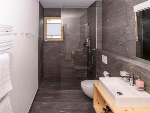 a bathroom with a sink and a toilet and a shower at Apartment Duai by Interhome in Müstair