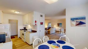 a kitchen and a living room with a table and chairs at Atlantic Breeze #4 in Jekyll Island