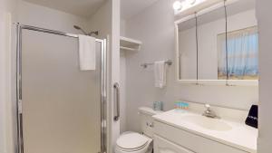 a bathroom with a shower and a toilet and a sink at Atlantic Breeze #4 in Jekyll Island +12 photos