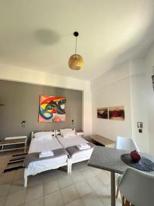 a bedroom with a bed and a table with chairs at Green Garden Studios in Koskinou