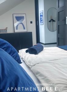 a bed with a blue pillow on top of it at Harmony House - Appartement Blue in Kołczewo