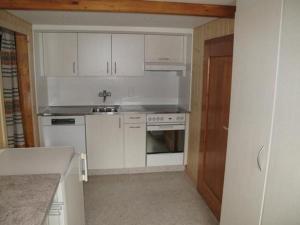 a kitchen with white cabinets and a stove top oven at Apartment Gubel by Interhome in Alt Sankt Johann