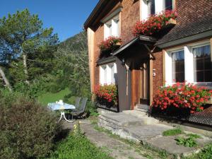 a house with a table and flowers in front of it at Apartment Gubel by Interhome in Alt Sankt Johann +9 photos