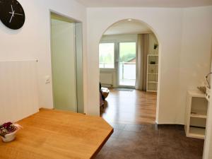 a living room with a clock and a wooden floor at Apartment Panoramablick by Interhome in Nesslau