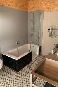 a bathroom with a bath tub and a shower at Apartment nirkwerk by Interhome in Schönengrund